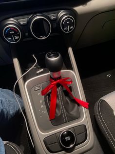 the interior of a car with a red ribbon on it's dash board and steering wheel