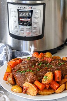 a white plate topped with beef and potatoes next to an instant pot roaster oven