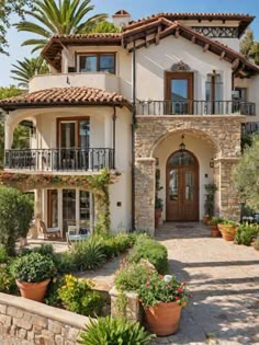 a large house with lots of windows and plants in front of the entrance to it