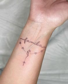 a woman's wrist tattoo with the word family on it