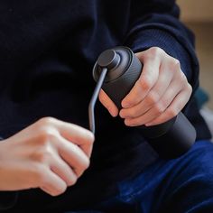 a person is holding a hair dryer in their hand while sitting on the floor