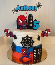 a spiderman birthday cake with the number five on it's top and decorations