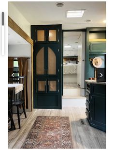 an open door leading to a kitchen and dining room with a rug on the floor