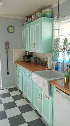 a kitchen with green cabinets and checkered flooring