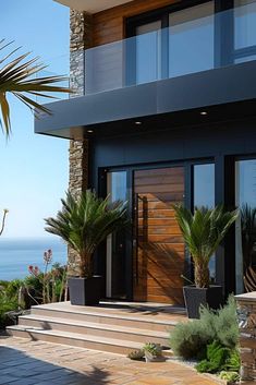 a house with some plants in front of it and an ocean view behind the house