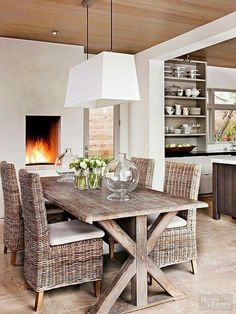 a dining room table with chairs around it and a fire place in the back ground