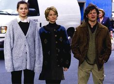 three people standing next to each other in front of a van