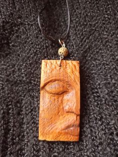 a wooden necklace with a buddha face on it