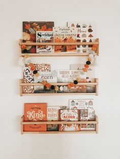 two wooden shelves filled with books on top of each other next to a white wall