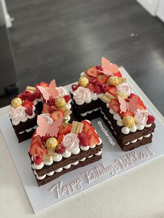 there is a cake that has been decorated with flowers and leaves on it, sitting on a table