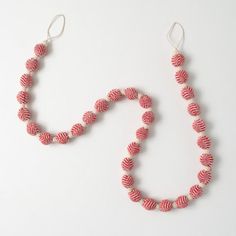 a red and white beaded necklace on a white surface with a pair of scissors