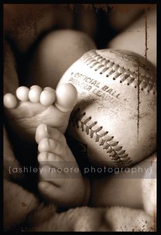 a black and white photo of a baby's feet with a baseball on it