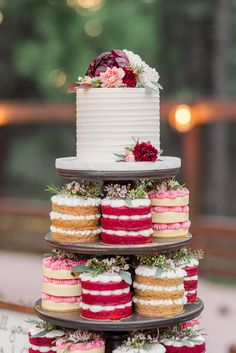 three tiered cake with red, white and blue frosting on top sitting on a table