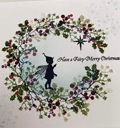 a christmas card with a silhouette of a fairy holding a star and holly wreath on it