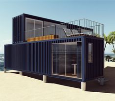 a large blue shipping container sitting on top of a sandy beach next to the ocean