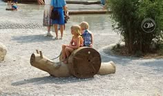 two children are sitting on an elephant statue