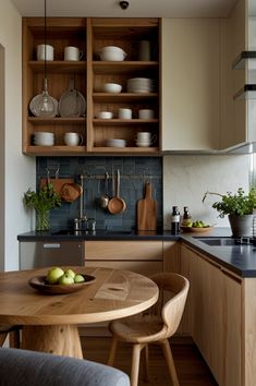 a kitchen with wooden cabinets and black counter tops next to a dining room table filled with green apples