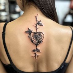 a woman's back tattoo with a rose and leaves on her upper back shoulder