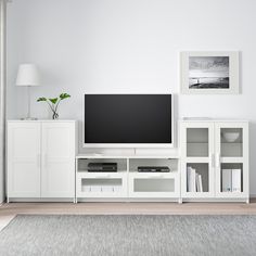 a flat screen tv sitting on top of a white entertainment center