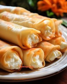 some food is on a white plate and sits on a table next to carrots