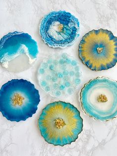 five blue and yellow plates sitting on top of a white countertop next to each other