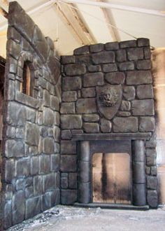 a stone fireplace in an unfinished room