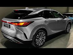 the rear end of a silver car parked in a garage with other cars behind it