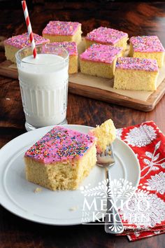 a piece of cake with pink sprinkles and a glass of milk