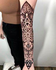 a woman's arm with an intricate tattoo design on the left forearm and right arm