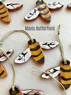 several bees are hanging from string on a table with the words mavis butterfield