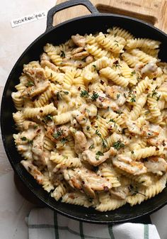 a skillet filled with chicken and pasta