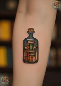 a tattoo with books in a bottle on the arm and behind it is a bookcase