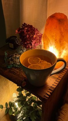 a bowl of soup on a table next to a rock lamp and potted plant