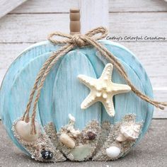 a blue pumpkin decorated with shells and starfish