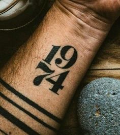 a man's wrist tattoo with the number forty four on it