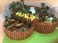 there are many different animals in the fake desert landscape made out of clay and palm trees