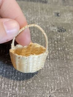 someone is holding a miniature basket in their hand