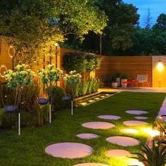 a garden with stepping stones lit up at night