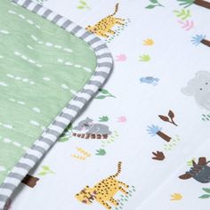 an image of a baby bedding set with giraffes and elephants on it