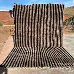 a large black and white striped blanket sitting on top of a sidewalk