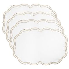 four white scalloped place mats with gold trimmings on each one side