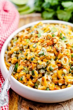 a white bowl filled with macaroni and cheese on top of a wooden table