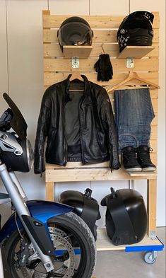 a motorcycle parked next to a wooden shelf filled with hats and jackets on top of it