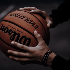 two hands holding a basketball in front of a black and white background with the word wow written on it