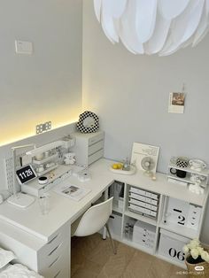 a white desk and chair in a small room with lights on the wall above it