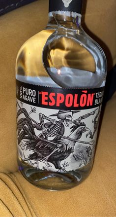 a bottle of espolon sitting on top of a brown table next to a black and white drawing