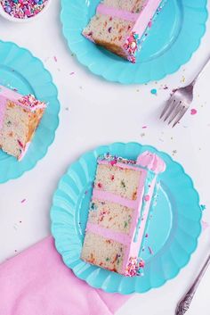 three slices of cake on blue plates with sprinkles and pink frosting