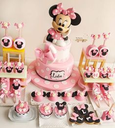 a minnie mouse cake and cupcakes are on display