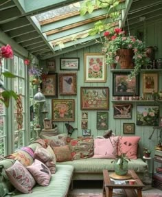 a living room filled with lots of furniture and pictures hanging on the wall above it