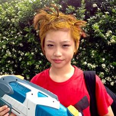 a young boy holding a nerf toy in his hand